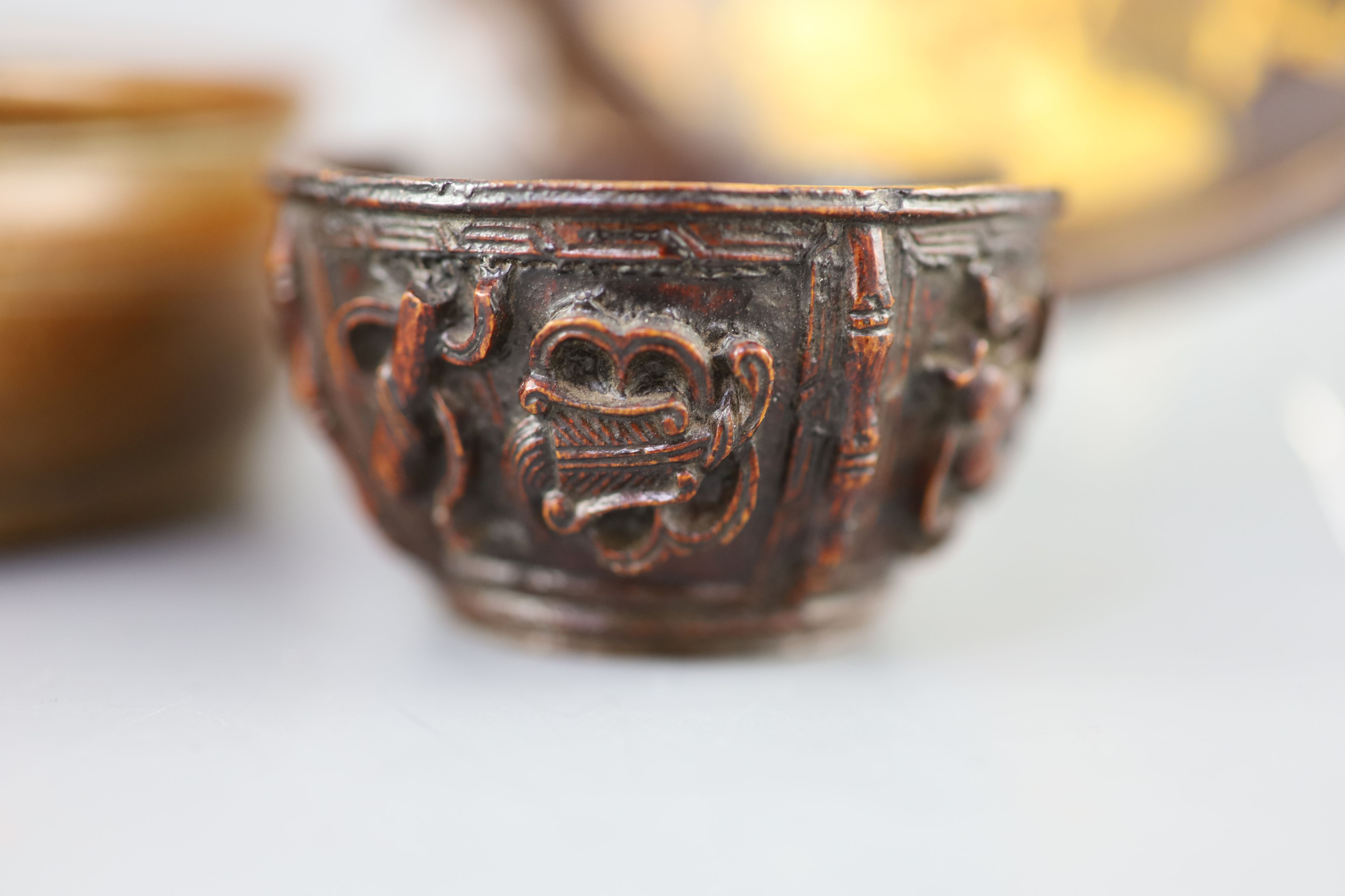 A Chinese carved bamboo cup, a plain bamboo brushwasher, 18th/19th century and a gilt decorated lacquer saucer dish, 17th century,